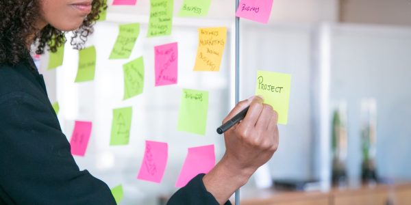 cropped-african-american-businesswoman-writing-sticker-with-marker-hand-office-employer-holding-pen-making-note